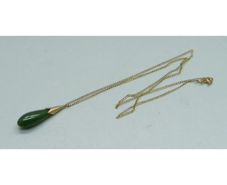 A jade pendant and on a 14ct gold chain, chain 0.6g 