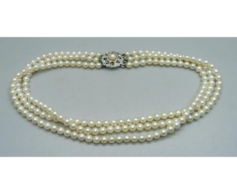 A three strand pearl necklace with 9ct white gold clasp set with diamonds, 33cm 