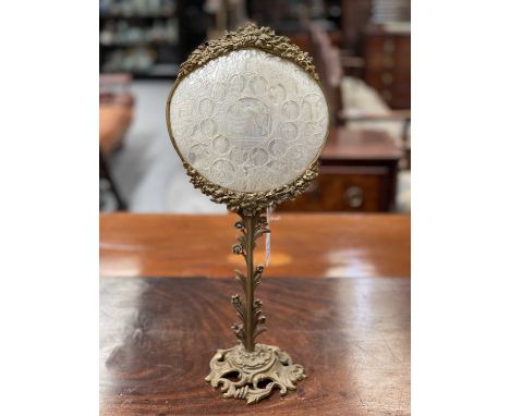 A 19TH CENTURY GILT-BRASS AND MOTHER-OF-PEARL TABLE SCREEN the shell carved with religious figures, with foliate cast crestin