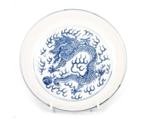 A CHINESE PORCELAIN BLUE AND WHITE DISH the central reserve painted with a dragon and pearl, the reverse bears six-character 