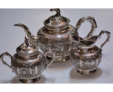A Chinese three piece white metal tea service, c. 1900, each piece of globular form, with bamboo-cast handles and spout, each