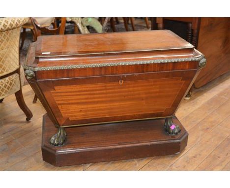 A handsome Regency brass-inlaid and mounted rosewood crossbanded mahogany cellarette, of sarcophagus form, the caddy top with