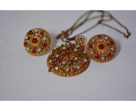 A suite of Indian coral and pearl mounted gold jewellery, a pendant and earrings en suite, each of circular form, the filigre