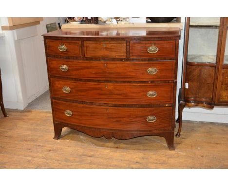 A George III bowfronted mahogany chest of drawers, with three frieze drawers over three long graduated drawers, each with ebo