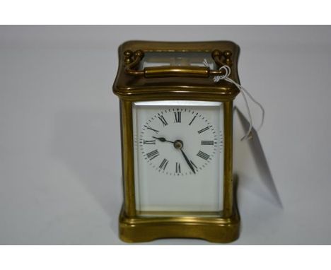 A French brass-cased carriage clock, early 20th century, of characteristic form, the white enamel dial with Roman numerals, s