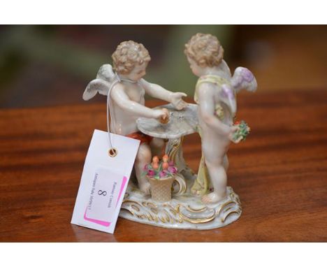 A Meissen figure group, c. 1900, of two putti playing dice at a table, a basket of flowers at their feet, on an oval base mod