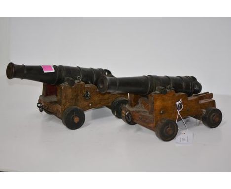 A pair of cast iron model cannon,  each with ring-cast barrel and mounted on an oak gun carriage. Length overall 28cm