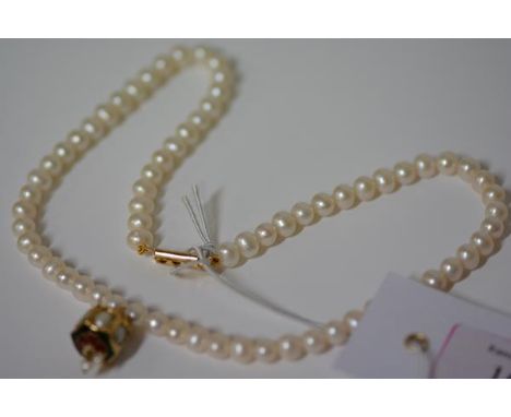 A single strand cultured pearl necklace, the uniform pearls suspending an enamel and pearl drop mounted in yellow metal, with