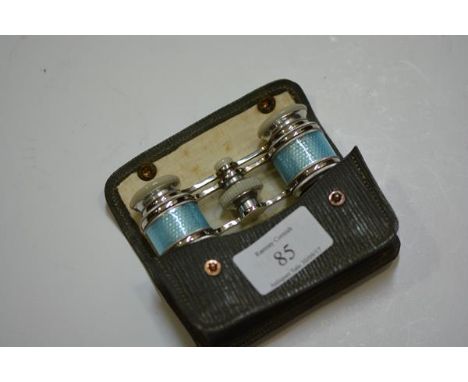 A pair of sky blue engine turned enamel and mother of pearl opera glasses, mounted in white metal, cased