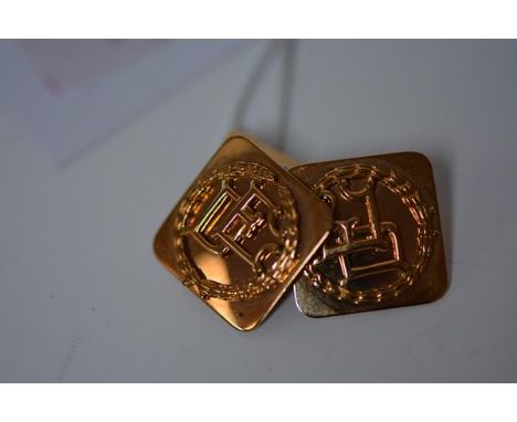 A pair of Indian yellow metal cufflinks, the square monogrammed plate with chain link to a scimitar shaped backplate, stamped
