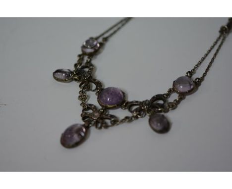 An amethyst and white metal necklace in the Edwardian taste, set with amethyst cabochons of varying sizes and shapes in a flo