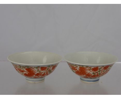 A pair of Chinese porcelain bowls depicting red phoenix in flight with chrysanthemum and scroll leaf design, everted rim, app