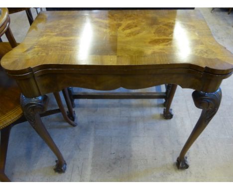 A Victorian Style Walnut Swivel Top Card Table, the table having scalloped corners on ball and claw feet and green baize top,