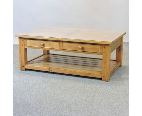 A light oak coffee table, with a glass top, 120cm