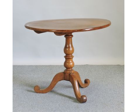 A light walnut tripod table, with a circular tilt top, 87cm