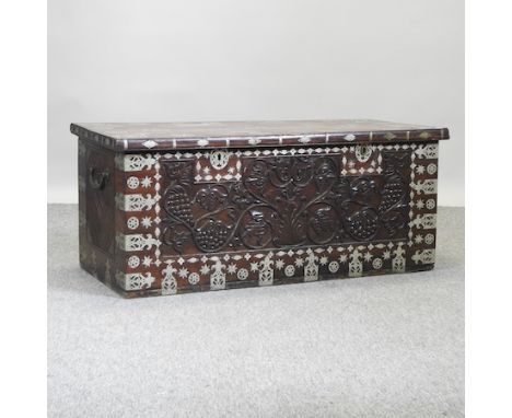 An eastern hardwood and metal bound trunk, with a carved front, 113cm