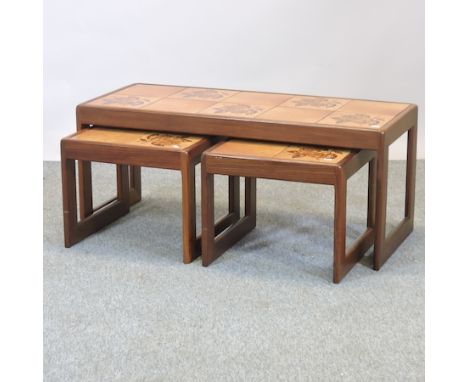 A 1970's nest of three tile top tables, largest 106cm