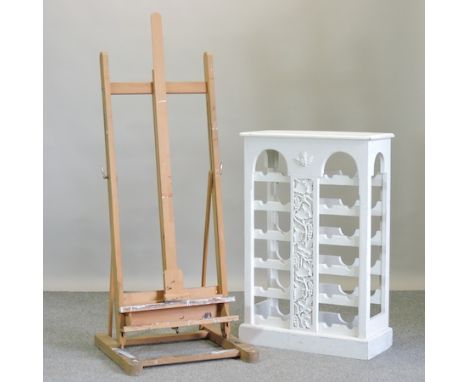 A beech artist's easel, 55cm, together with a white painted wine rack with vine decoration