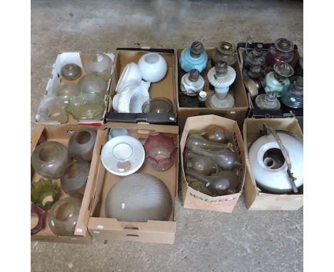 A collection of oil lamps, shades and funnels, together with a hanging oil lamp with a white glass shade