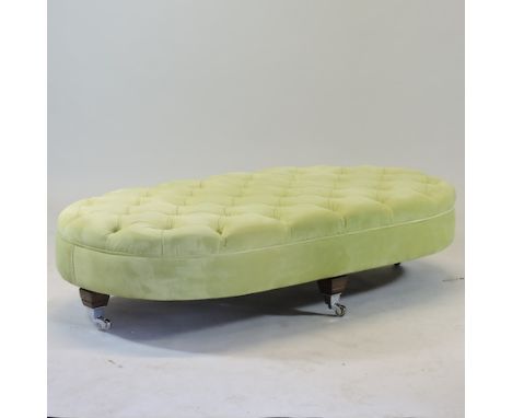 A green button upholstered footstool, on castors, 178 x 75cm