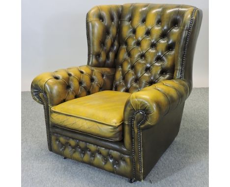 A leather upholstered button back wing armchair