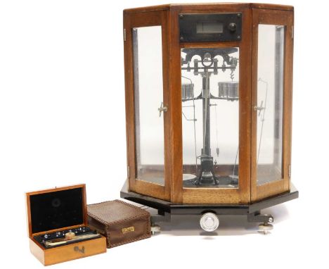 A well-made set of laboratory scales in mahogany glazed case standing on black glass plinth, chrome fittings, no visible make