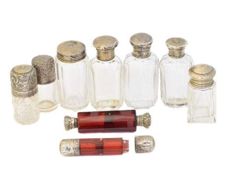 A selection of silver topped bottles, to include two cranberry glass double ended scent bottles, and seven clear class silver