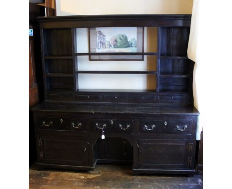 A George II oak dresser and rack, the open backed rack with six divided shelves, the base with five small spice drawers to to