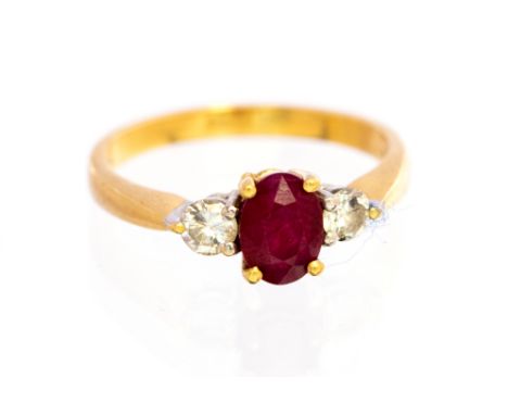 A ruby and diamond three stone ring, the central oval faceted ruby approx 7mm x 5mm, the two brilliant cut diamonds, one each