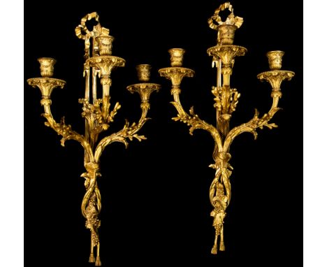 A pair of 19th Century ormolu triple light wall sconces, of Louis XVI design, ribbon finials, cast acanthus light branches, t