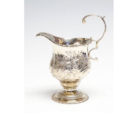 A George III silver ogee shaped cream jug, the body profusely chased with flowers and foliage beneath gadroon rim and S-scrol