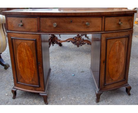 A 19th Century mahogany bow fronted kneehole desk, having three drawers and two doors, raised on splayed bracket feet, 81cm h