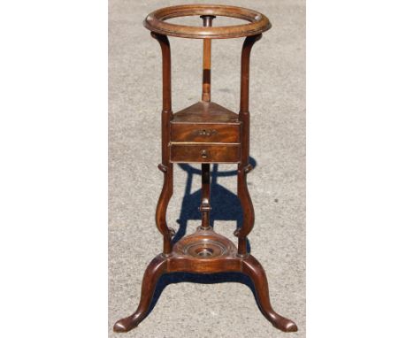 A George III mahogany basin stand, of triangular form, circa 1760, the middle section having two small drawers, raised on sha