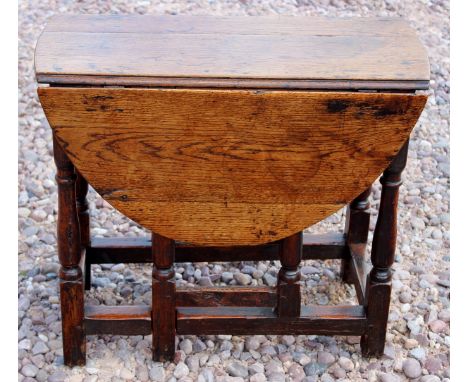 A very small oak gate leg table with beech stretchers of George I period circa 1720, wonderful colour and patina measuring (o