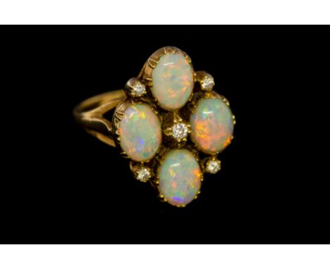 An opal four stone and diamond set cluster yellow gold ring, the quatrafoil cluster head set with four oval cabochon cut blac