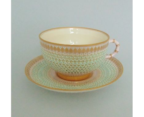 A Royal Worcester Reticulated tea cup and saucer, picked out in pink blue turquoise and gilt, circa 1887,  standard printed m