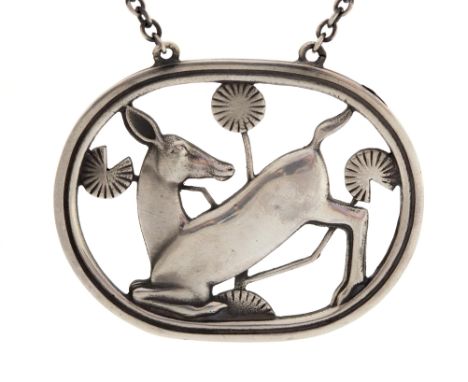 Georg Jensen, a Danish Modernist silver pendant, Kneeling Deer, approx 4.5cm wide, pattern number 95, suspended on a white me