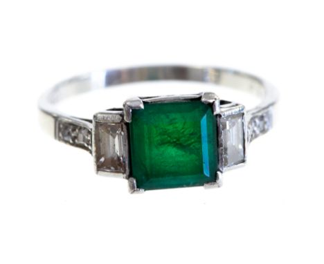 An Art Deco style emerald and diamond three stone platinum ring, the central square step cut emerald approx 0.75ct, two bague