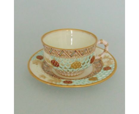A Royal Worcester Reticulated tea cup and saucer, with honeycomb piercing picked out in turquoise,  pink, gilt and jewelled, 