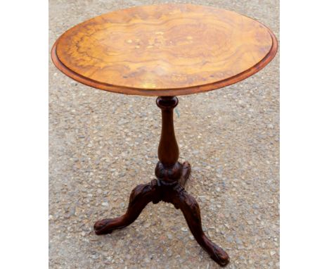 A mid Victorian walnut tripod table, the figured top raised on a baluster turned column, standing on three carved cabriole le