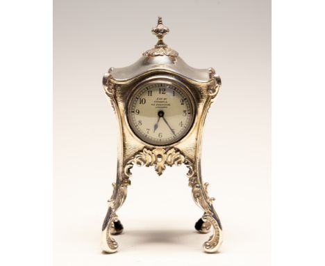 An Art Nouveau silver mounted dressing table clock, the shaped square body with wavy top surmounted by knop shaped finial, on