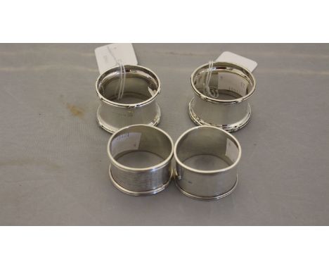 Four various silver napkin rings, comprising a pair of Walker and Hall napkin rings, Birmingham 1935, plus two others, one wi