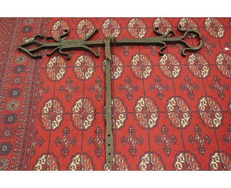 A pair of Tudor Gothic building iron tie-anchors, circa 1552, with witch protection markings, width 108cm (2)Provenance: from