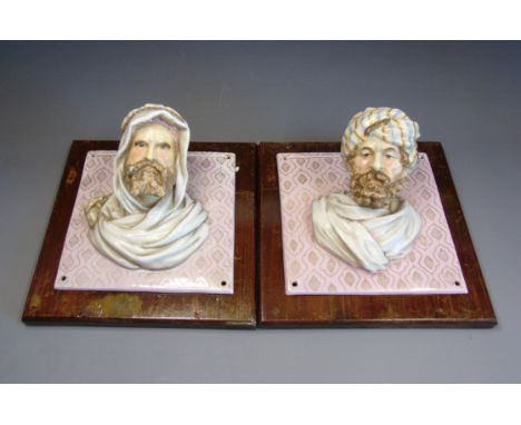 A pair of European hard paste porcelain wall plaques circa 1890 in the form of pretruding Arab heads upon a square tile with 