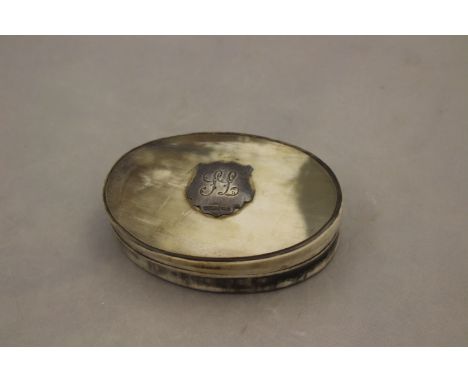 A 19th Century oval horn snuff box, applied with silver shield shape cartouche, 'W.D & Co', approx 9.5cm long