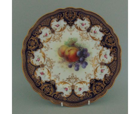 A Royal Worcester cabinet plate, painted with fruit by Richard Seabright, with a cobalt blue and gilt border with pink roses 