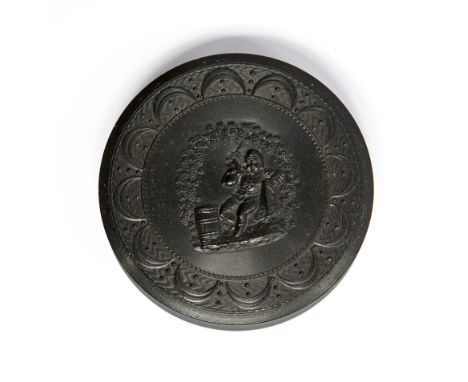 A 19th Century circular pressed horn snuff box, the cover with a figure of a man drinking ale, diameter 8cm 