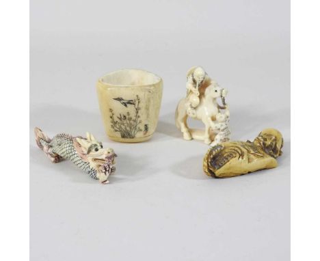 An early 20th century Japanese netsuke, in the form of a man on a horse, 5cm high, together with three other carvings