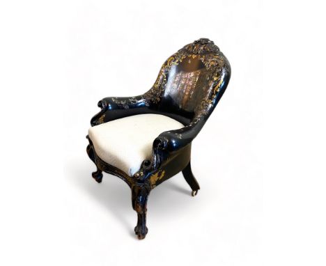 A mid Victorian papier m&acirc;ch&eacute; armchair 
Decorated with mother of pearl and gilt highlights and with a scene of th