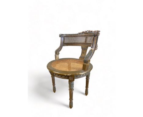 A Louis XVI style carved giltwood painted and caned fauteuil
The curved back and downswept arms above a circular seat on leaf